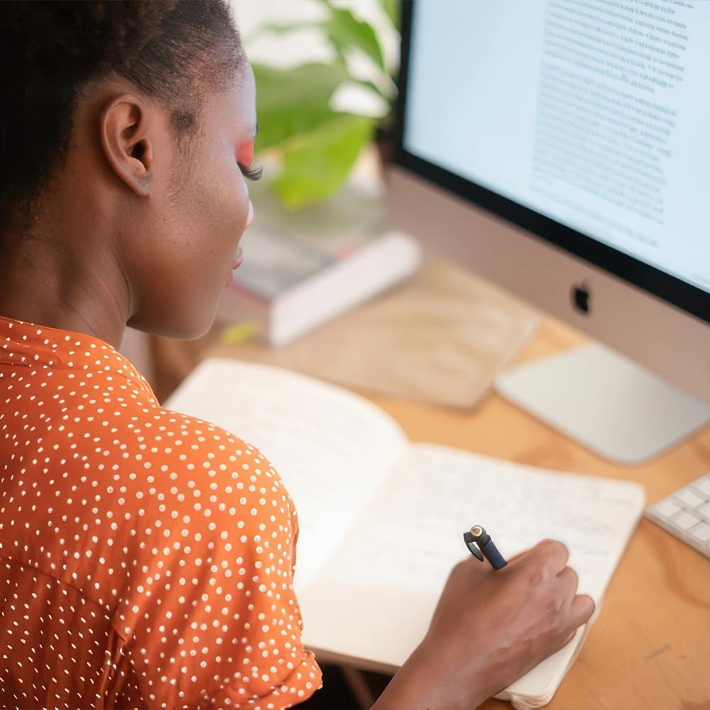 Young Woman At Desk Writing